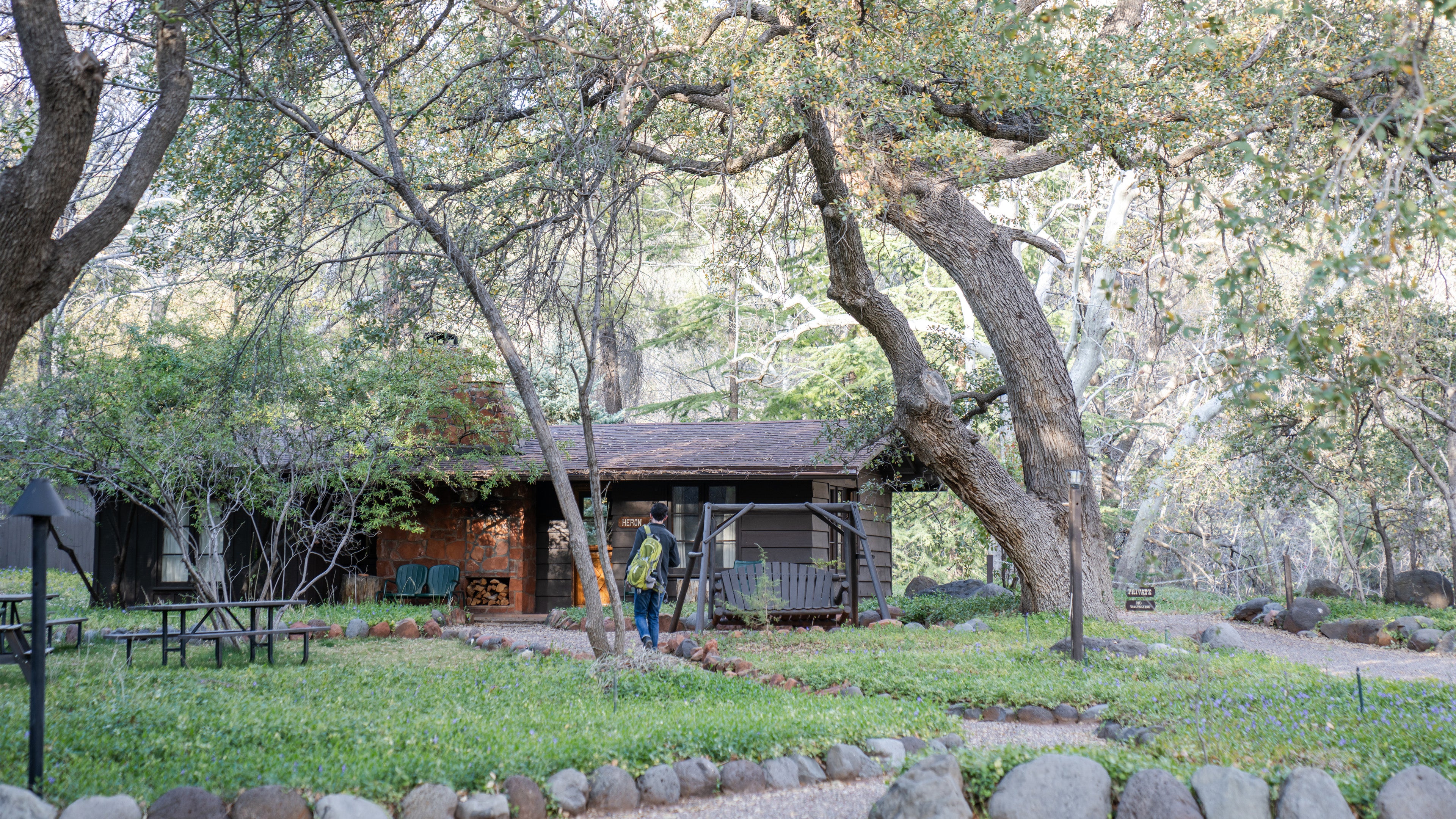 Wooden cabin nestled among trees in a park-like setting